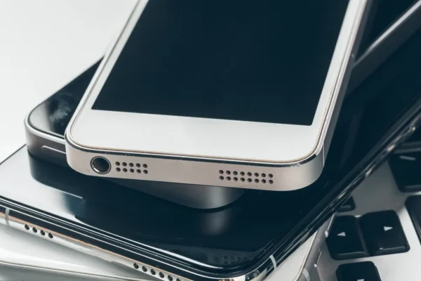 Close-up of a stack of used smartphones placed on a keyboard, representing device reuse and recycling as part of the Reconnect Project to reduce e-waste.